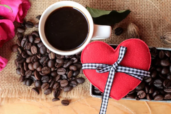 Kaffee mit Kaffeebohnen und roten Herzen. — Stockfoto