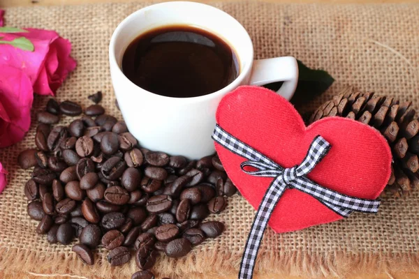 Coffee with coffee beans and red hearts. — Stock Photo, Image