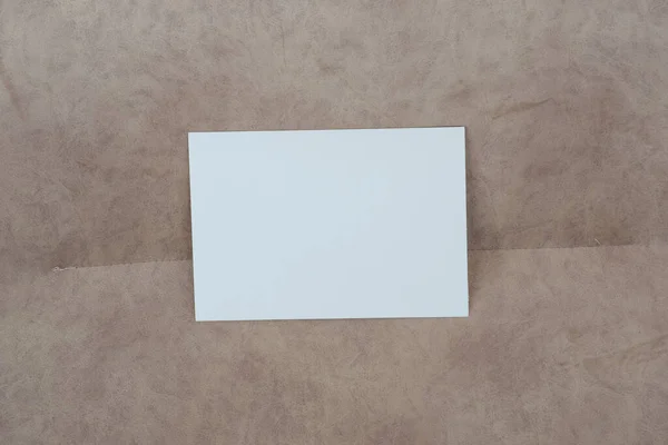 Composición maqueta de tarjeta blanca en blanco. Fondo textil abstracto beige y gris. Copiar espacio Imagen de archivo