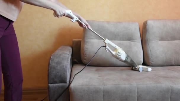 Wanita menyedot sebuah sofa dengan vacuum cleaner putih di hotel atau dekat rumahnya. Konsep kebersihan dan perawatan rumah — Stok Video