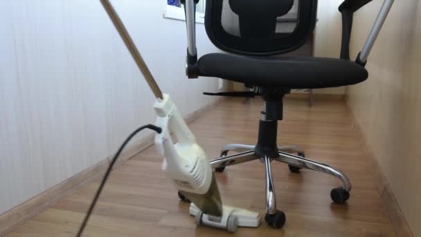 Kadın, ofisini süpürge ile süpürge ve elektrikli sandalyeyle süpürüyor ya da evini kapatıyor. Temizlik ve ev bakımı kavramı — Stok video