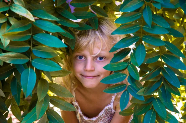 Lovely little child and green leaves — Stock Photo, Image