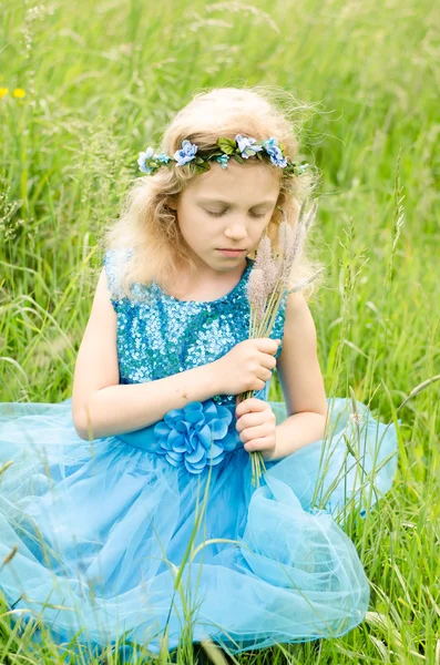 Blond meisje in blauwe jurk — Stockfoto