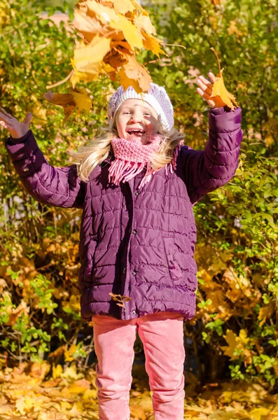 Glückliches Kind, das mit Herbstblättern spielt — Stockfoto