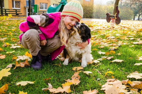 Criança e cão abraçando juntos — Fotografia de Stock