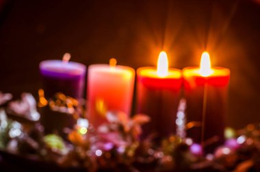 Siyah arkaplanda pembe ve mor renkte mumlar var.