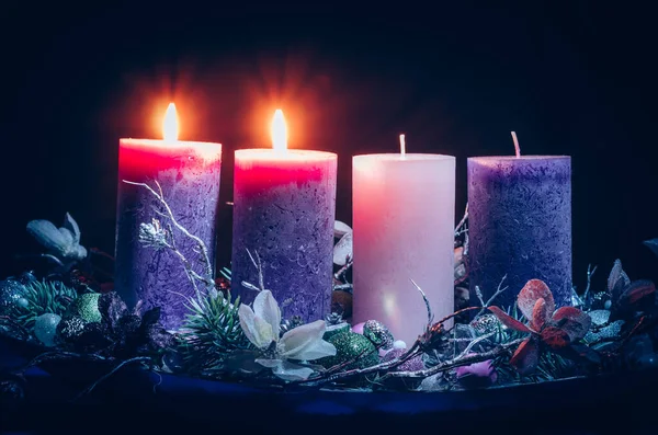 黑色背景花环装饰中的粉色和紫色蜡烛 — 图库照片