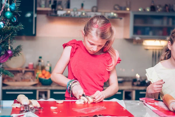 素敵なブロンドの女の子家庭のキッチンでクリスマスの雰囲気の中でお菓子を準備 — ストック写真