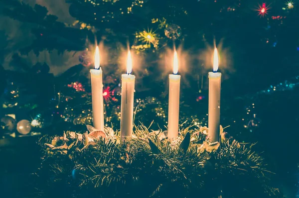クリスマスツリーを背景に4本のろうそくを燃やす — ストック写真