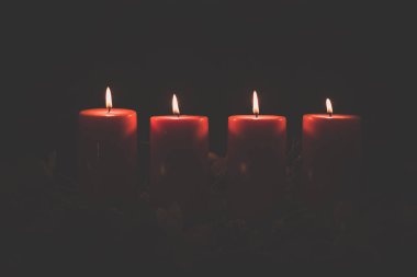 Aydınlık ve sihirle dolu geleneksel kristian atmosferiyle yanan dört mum, kopyala uzay