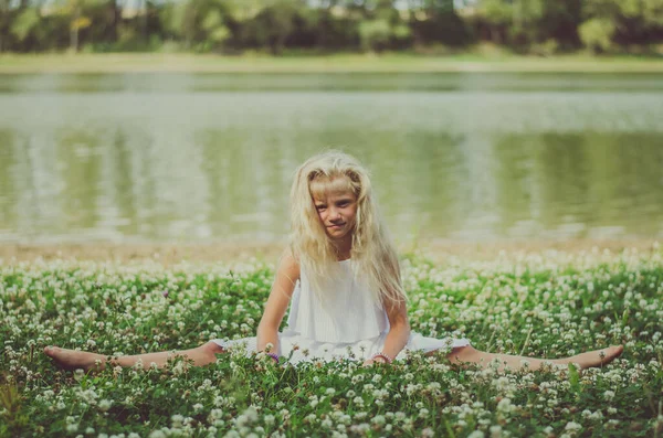 Rozkošné Dítě Sedí Trávě Bílými Květy Rybníka Relaxační Podél — Stock fotografie