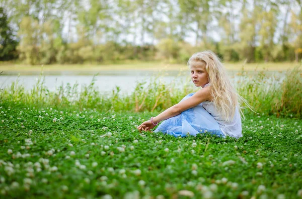 Bedårande Flicka Med Långt Blont Hår Sitter Grön Klöver Blomsteräng — Stockfoto