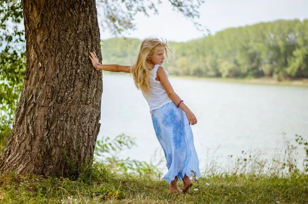 Bedårande Barn Med Långt Blont Hår Som Står Vid Trädet — Stockfoto