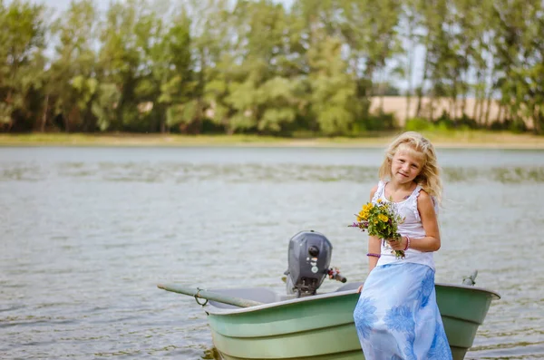 川のそばの船に座っている素敵な女の子 ロイヤリティフリーのストック写真