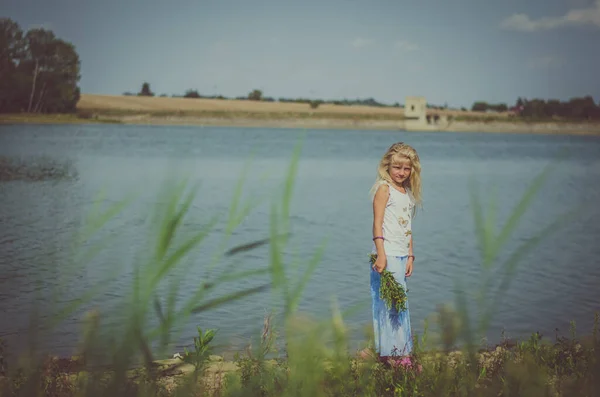 Kleines Blondes Mädchen Mit Blumenstrauß Teich Auf Der Grünen Sommerwiese Stockfoto