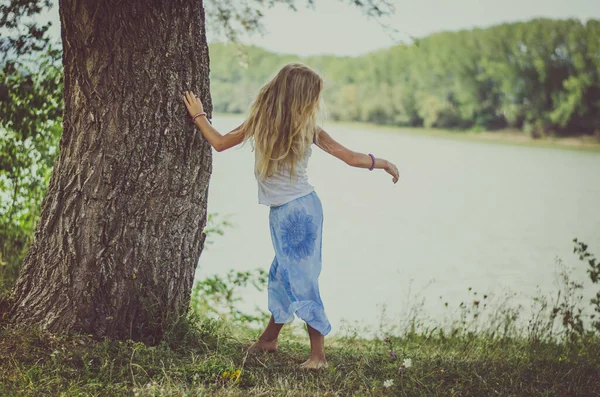 Entzückendes Kind Mit Langen Blonden Haaren Das Baum Neben Dem Stockbild