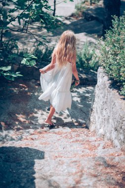 Uzun beyaz elbiseli, sağlıklı, uzun sarı saçlı güzel bir kız.