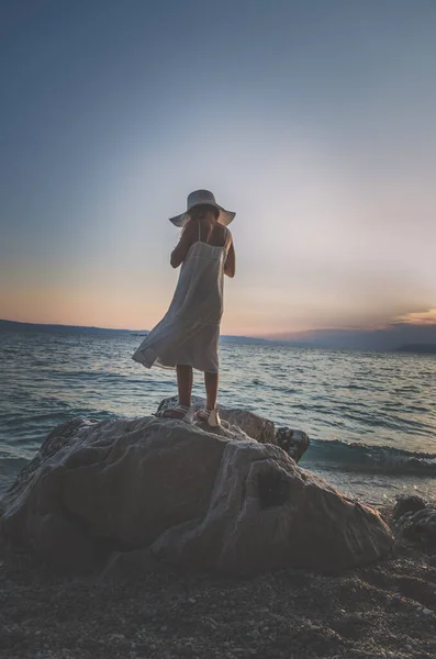 Menina Vestido Branco Chapéu Com Mãos Ascensão Rocha Pelo Mar — Fotografia de Stock