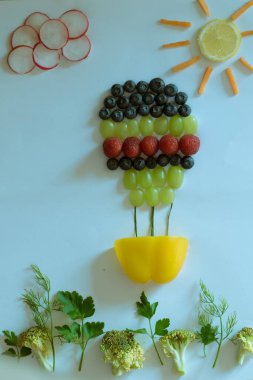 Renkli sebzelerden yapılmış balon şekli ve üzüm, yabanmersini ve çilek gibi meyveler.