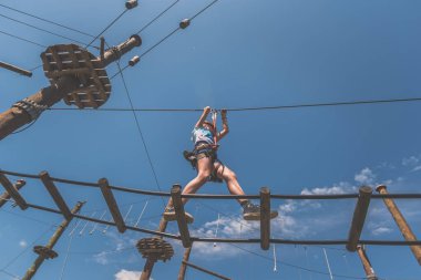 İpe tırmanan çocuk. İp çekme parkında. Açık havada güzel bir yaz gününde.