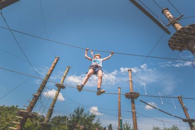 İpe tırmanan çocuk. İp çekme parkında. Açık havada güzel bir yaz gününde.