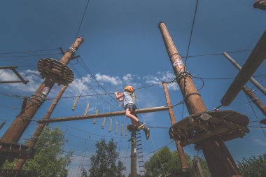 İpe tırmanan çocuk. İp çekme parkında. Açık havada güzel bir yaz gününde.