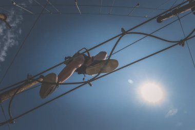 Cesur çocuk atraksiyon parkında ipe tırmanıyor. Profesyonel halat inşaatında. Açık havada, açık yaz gününde.