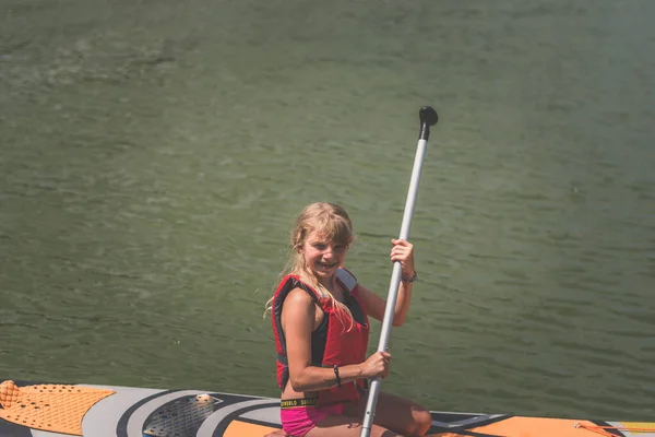 여름날에는 안전에 수있는 조끼를 소녀가물 위에서 — 스톡 사진