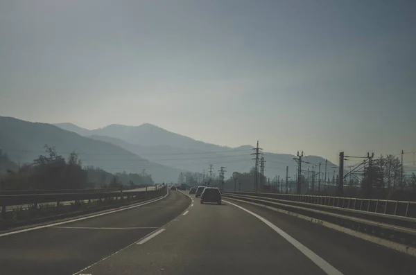 stock image views from the car to the highway leading among forest and  mountains