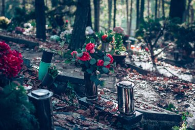 Sonbaharda mezarlıkta mum yakmak ve çiçeklerle süslenmek.