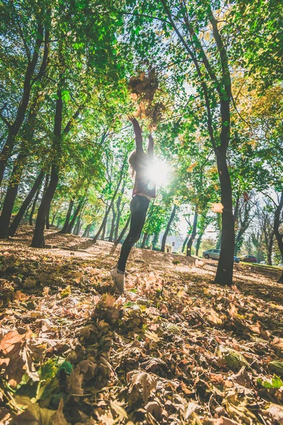 快乐的女孩在秋天的公园里在树叶间跳舞 — 图库照片