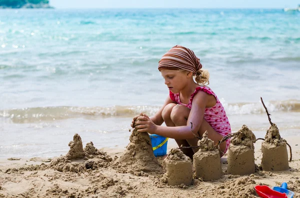 Criança construindo castelos de areia — Fotografia de Stock