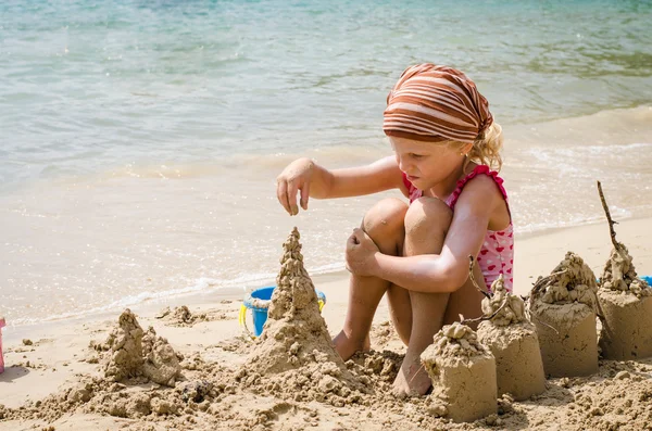 Menina construindo castelos de areia — Fotografia de Stock