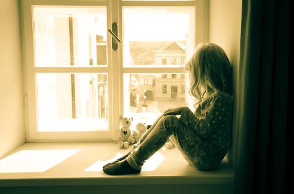 Chica mirando por encima de ventana — Foto de Stock