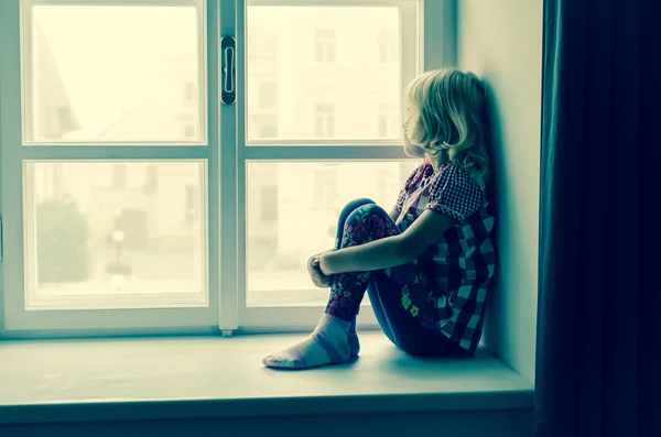 Girl looking through window — Stock Photo, Image