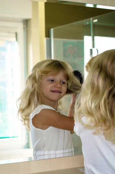 Blond girl brushing hair — Stock Photo, Image