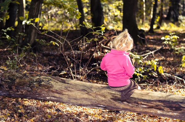 Blond meisje uit rearview in forrest — Stockfoto