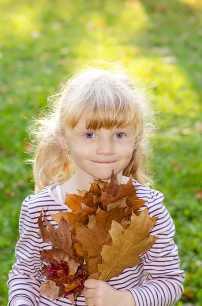Blondes Mädchen mit Herbstblättern — Stockfoto