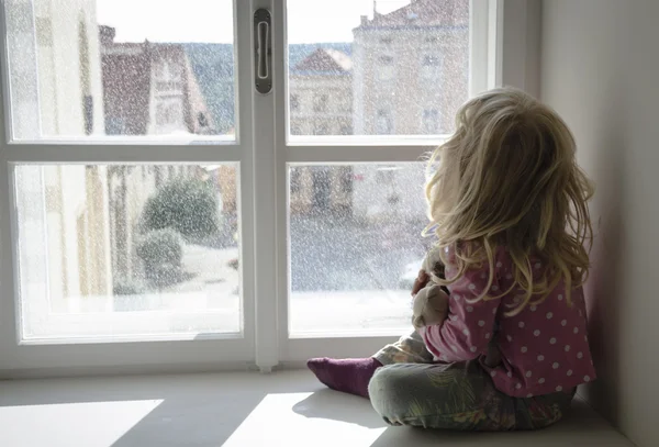 Girl looking through window — Stock Photo, Image