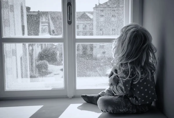 girl looking through window