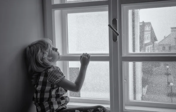 Girl looking through window — Stock Photo, Image