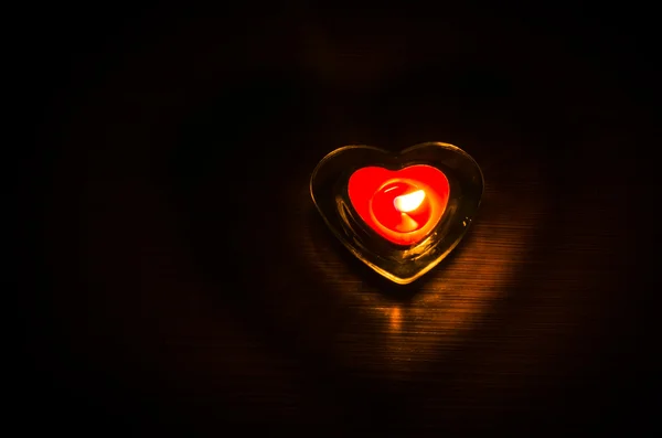 Горящая красная свеча в форме сердца — стоковое фото