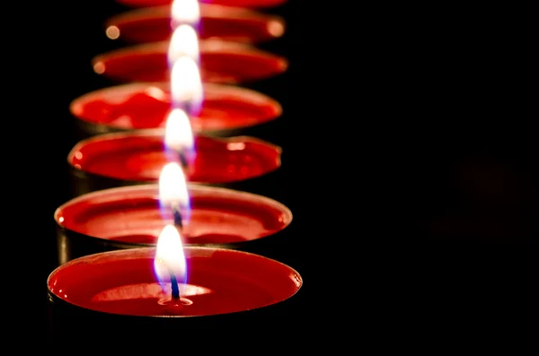 Velas vermelhas queimando em uma fileira — Fotografia de Stock