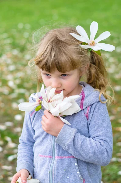 Prachtige blond meisje ruikende bloemen — Stockfoto