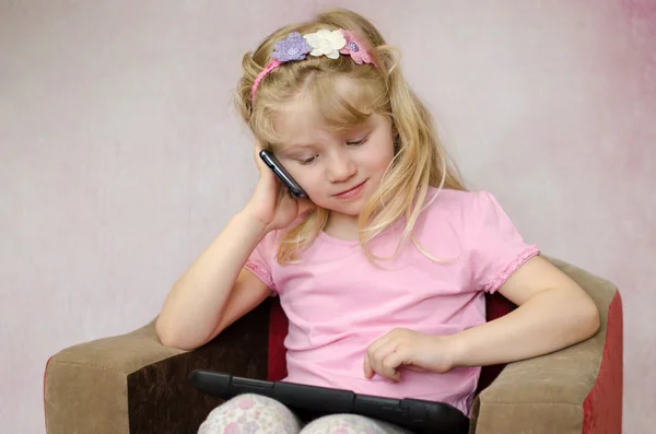 Menina com tablet e telefone celular — Fotografia de Stock