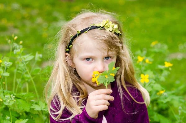 Prachtige blond meisje ruikende bloemen — Stockfoto
