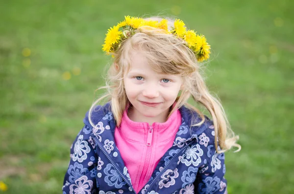 Belle fille avec des fleurs de pissenlit sur la tête — Photo