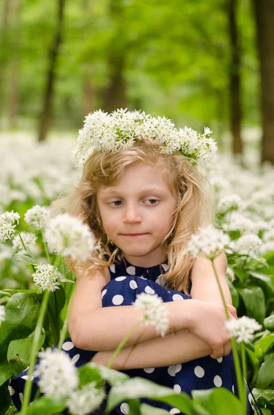 Beautiful blond girl sitting in white meadow — Stock Photo, Image