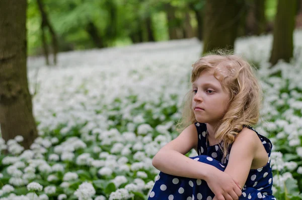 Menina sentada no prado branco — Fotografia de Stock