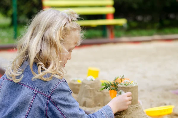 Flicka leker med sand — Stockfoto